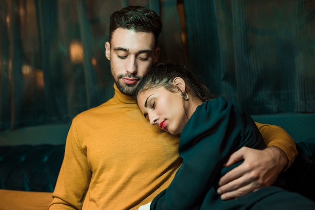 Man hugging woman lying on shoulder