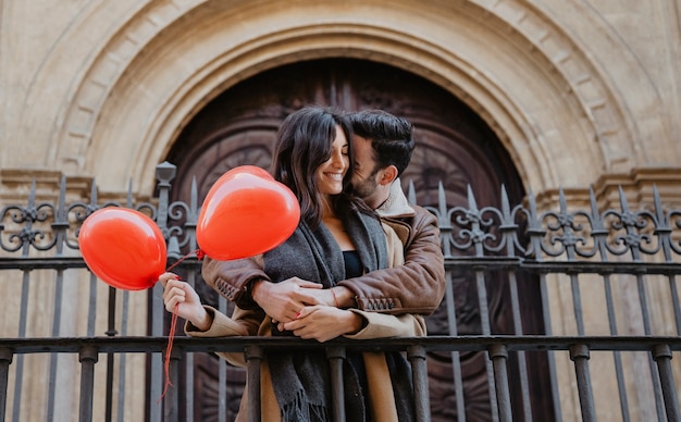 Free Photo man hugging woman near fence