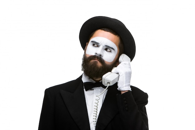 Man in the image mime holding a handset.