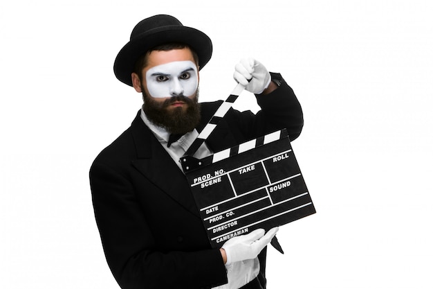 man in the image mime with movie board