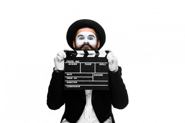 Man in the image mime with movie board