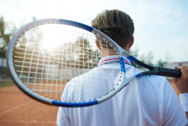 Man is holding a tennis racket