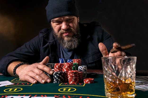 Man is playing poker. Emotional fail in game, game over for card player, man very angry with foolish choices, losing all the chips on bank. Concept of victory and loosing