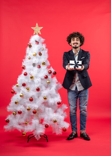 A man is standing next to the Christmas tree