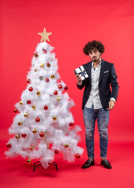 A man is standing next to the Christmas tree