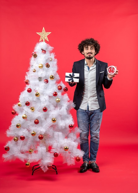 A man is standing next to the Christmas tree