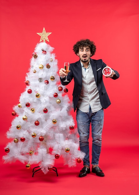 A man is standing next to the Christmas tree