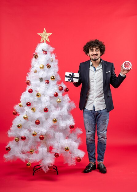 A man is standing next to the Christmas tree