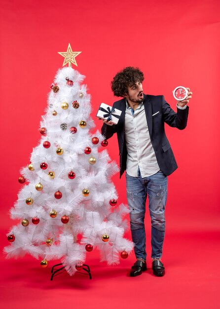 A man is standing next to the Christmas tree