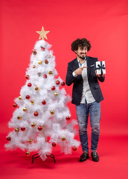 A man is standing next to the Christmas tree