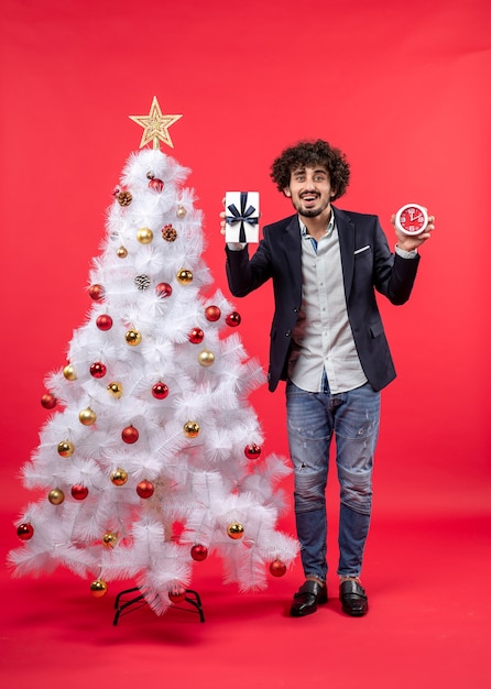 A man is standing next to the Christmas tree