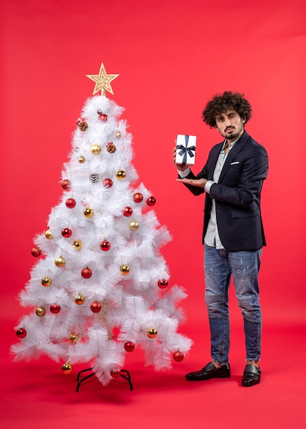 A man is standing next to the Christmas tree