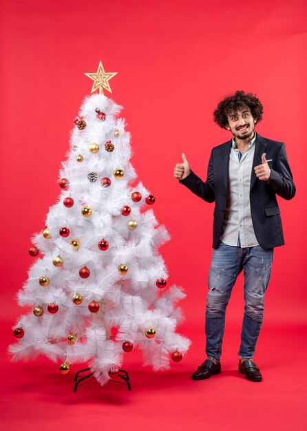 A man is standing next to the Christmas tree