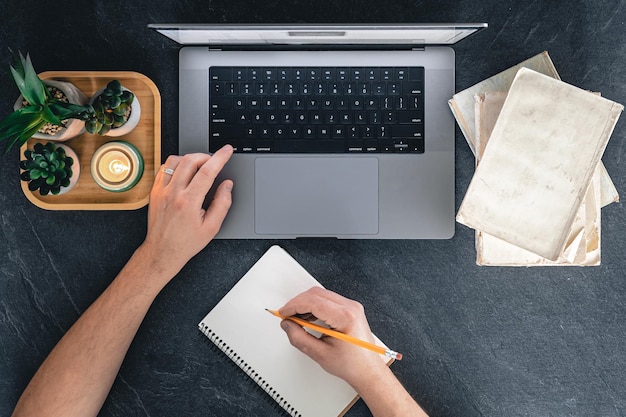 Free Photo a man is using a laptop books and a notebook top view