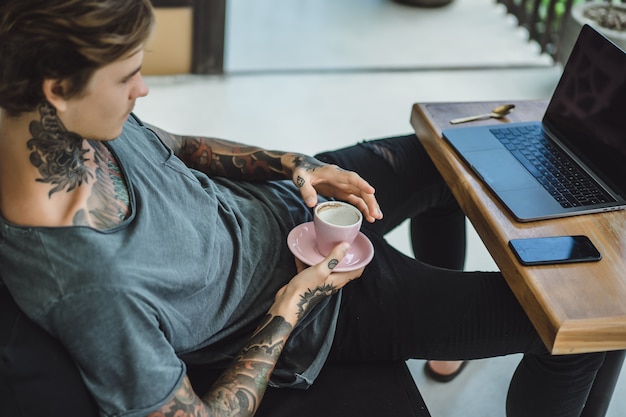 Free photo man is working in a cafe. concept of freelancing, coffee and laptop