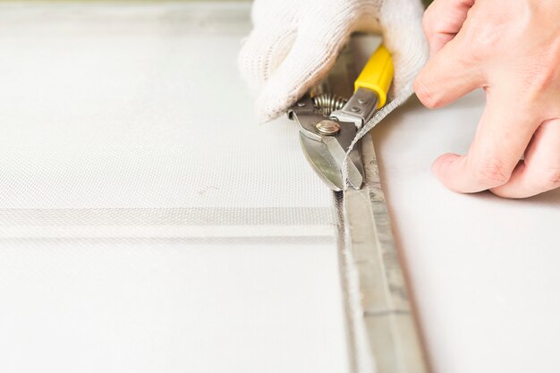 Man is working with mosquito wire screen installation