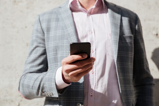 Man in jacket holding mobile phone