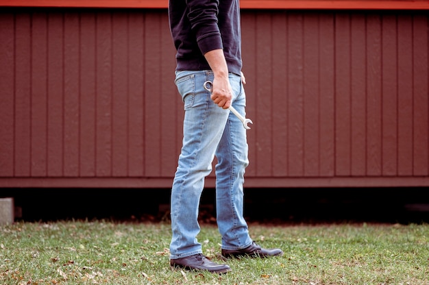 man in jeans holding a wrench