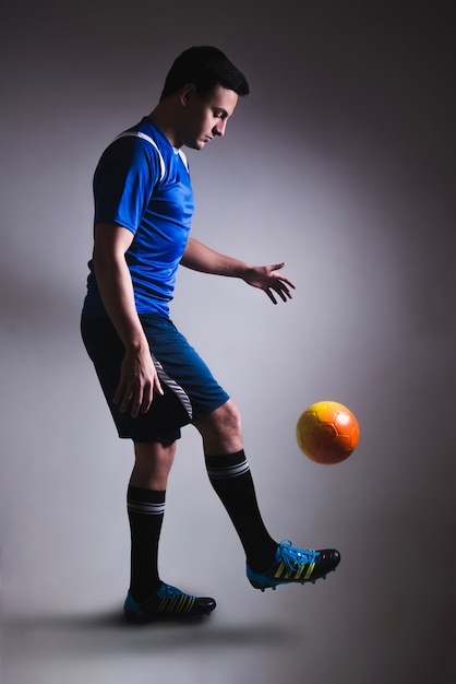 Free photo man juggling football