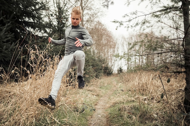 Man jumping on the forest trail