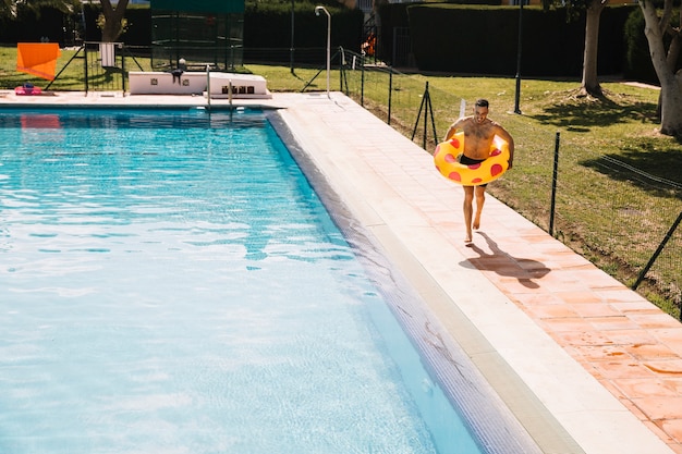 Free photo man jumping into pool