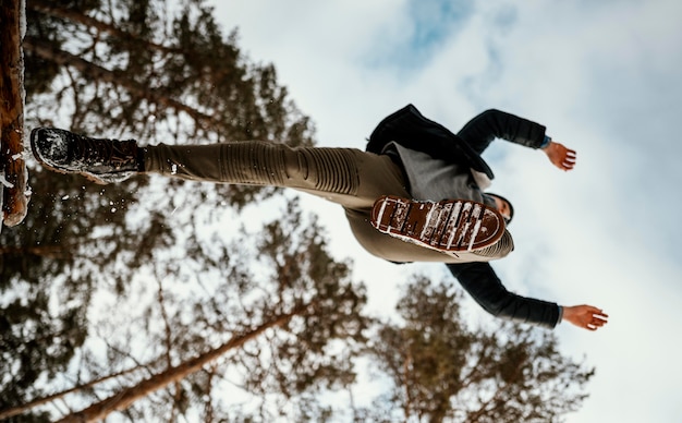 Free Photo man jumping outdoors in nature during winter