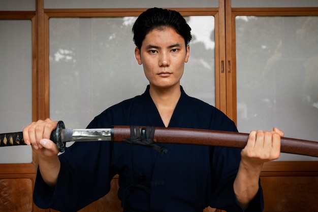 Man in kimono holding sword front view