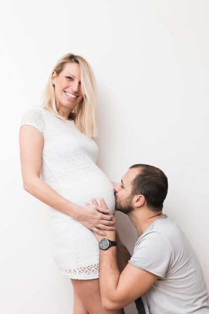 Man kissing belly of pregnant woman