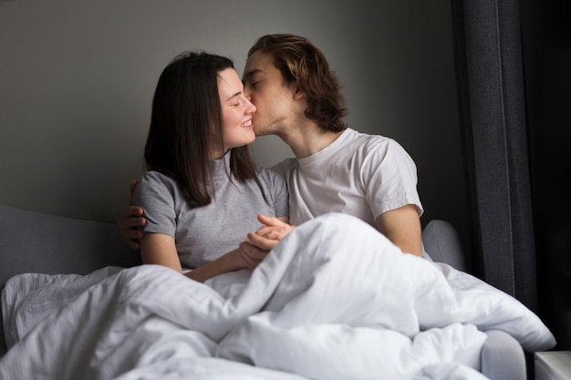 Man kissing girlfriend while holding hands