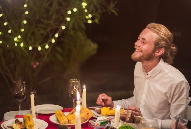 Free photo man laughing while sitting at festive table