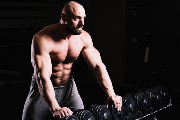 Man leaning on dumbbells