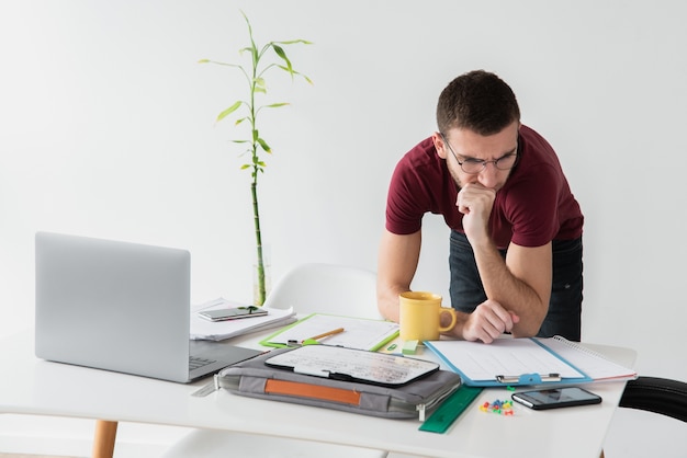 Man leaning on his desk and being focused