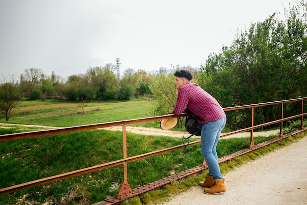 Man leaning on railing looking at nature