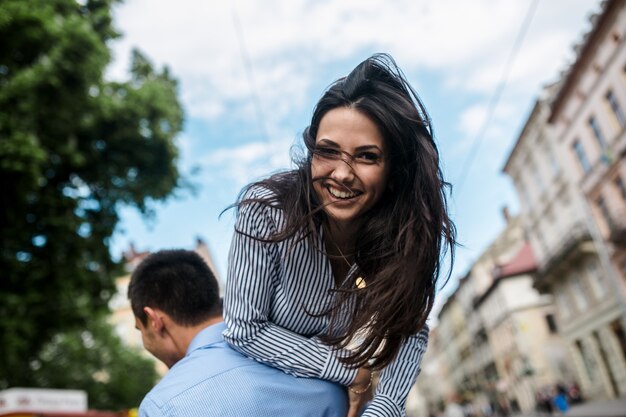 Man lifting charming girl on shoulders