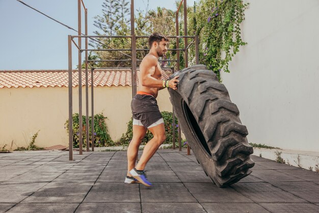 Man lifting tractor wheel