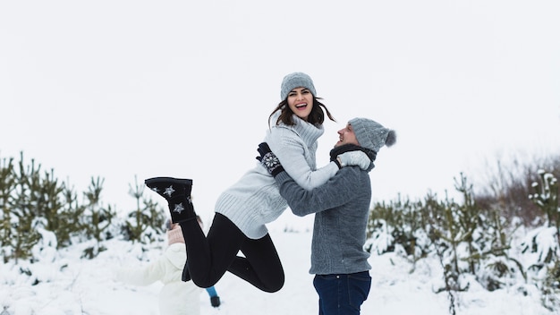 Man lifting woman during winter walk