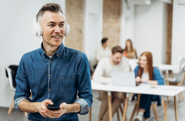 Free photo man listening to music at a business meeting