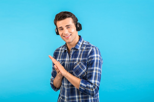  man listening to music on wireless headphones having fun modern style happy emotional mood isolated on blue