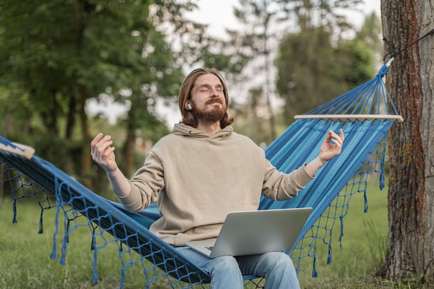 Man listening to zen music while sitting on hammock