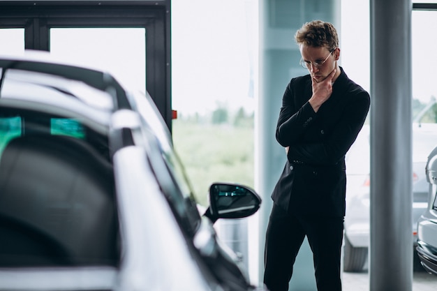 Man looking at a car and thinking of a purchase