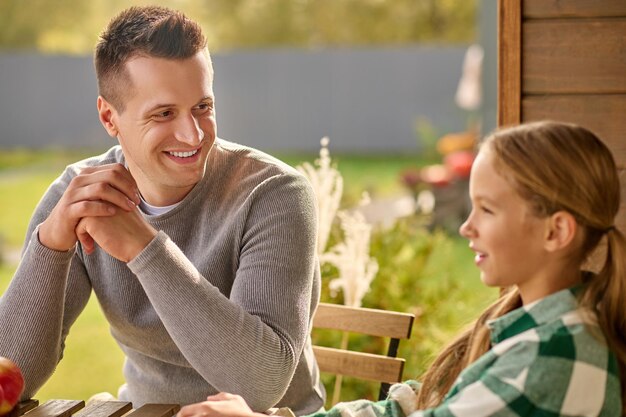 Man looking closely at girl telling story