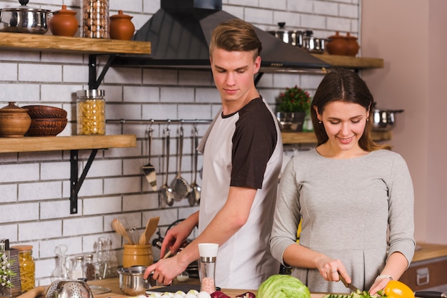 Man looking at cooking girlfriend