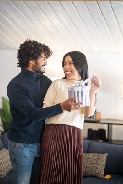 Man looking giving gift to joyful woman