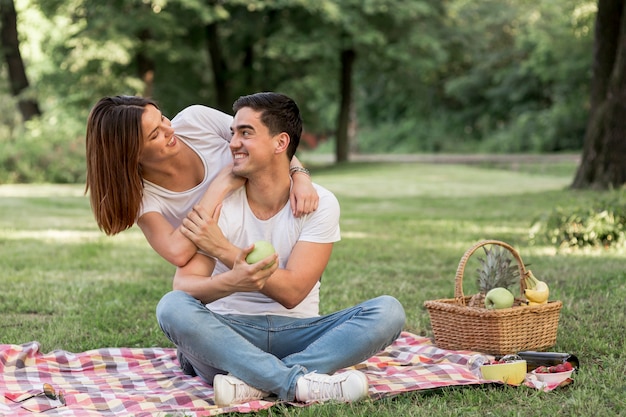 Man looking at his girlfriend while holding an apple