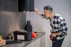 Free photo man looking at illumination of kitchen hood