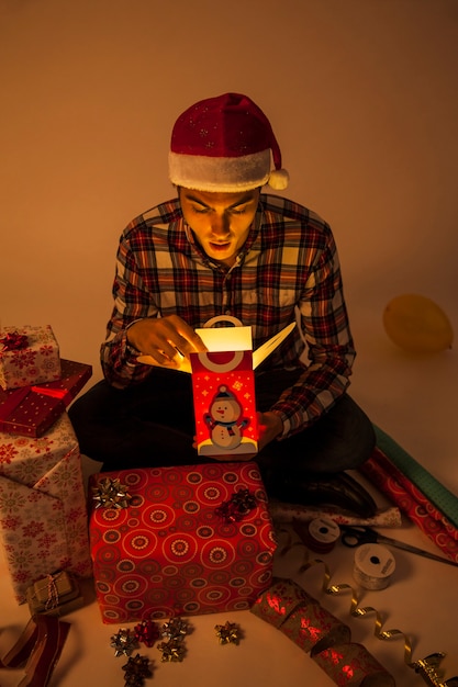 Free photo man looking into gift box