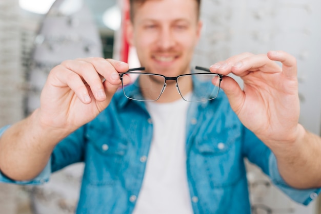 Free Photo man looking for new glasses at optometrist