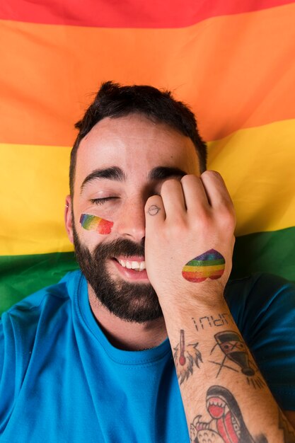 Man lying on LGBT flag