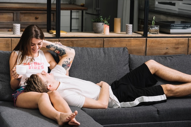 Free photo man lying on woman lap on couch