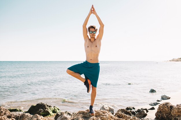 Man making balance exercise at the beach